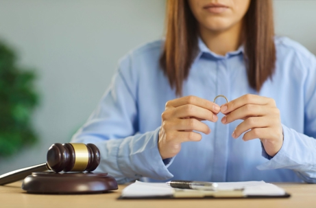 Woman holding ring next to a judge's gavel